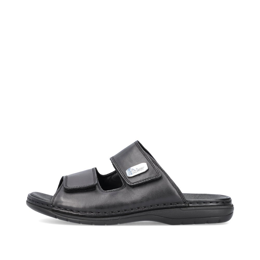 Black Rieker men´s mules 25590-00 with a hook and loop fastener. Outside of the shoe.