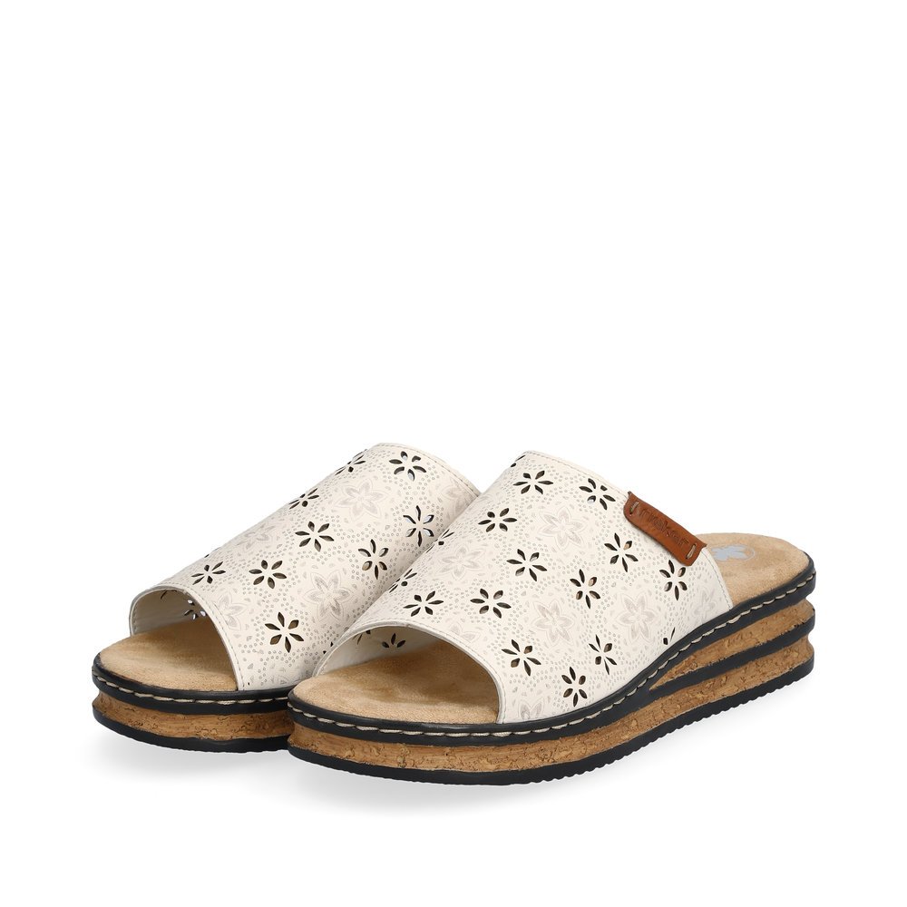 Beige Rieker women´s mules 62955-60 in perforated look as well as slim fit E 1/2. Shoes laterally.