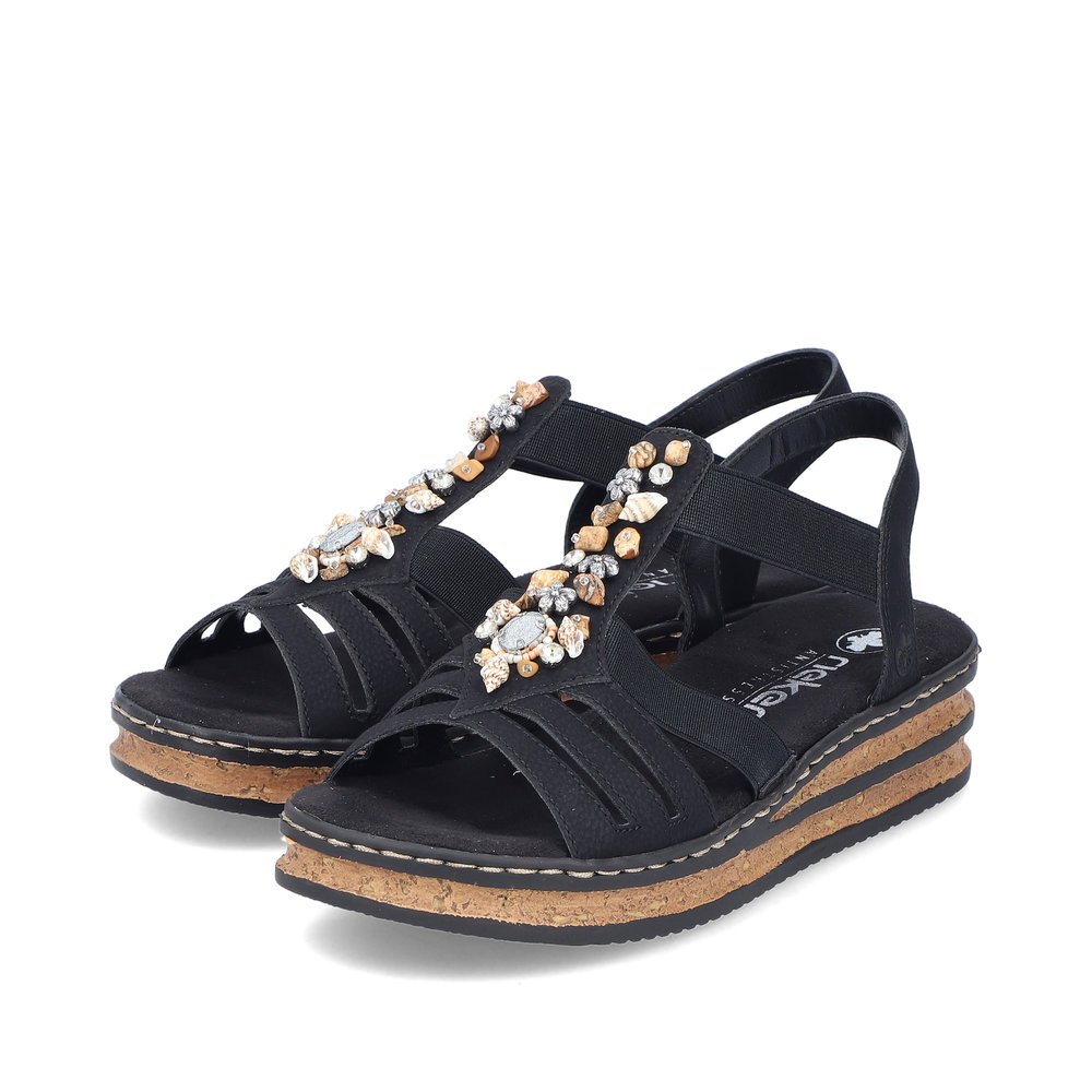Rieker sandales compensées noires femmes 62949-00 avec insert élastique. Chaussures inclinée sur le côté.