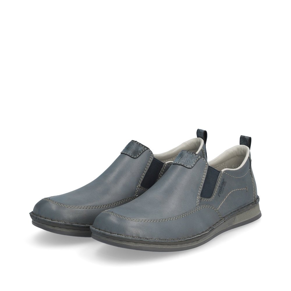 Blaue Rieker Herren Slipper 05450-12 mit Elastikeinsatz sowie braunen Ziernähten. Schuhpaar seitlich schräg.