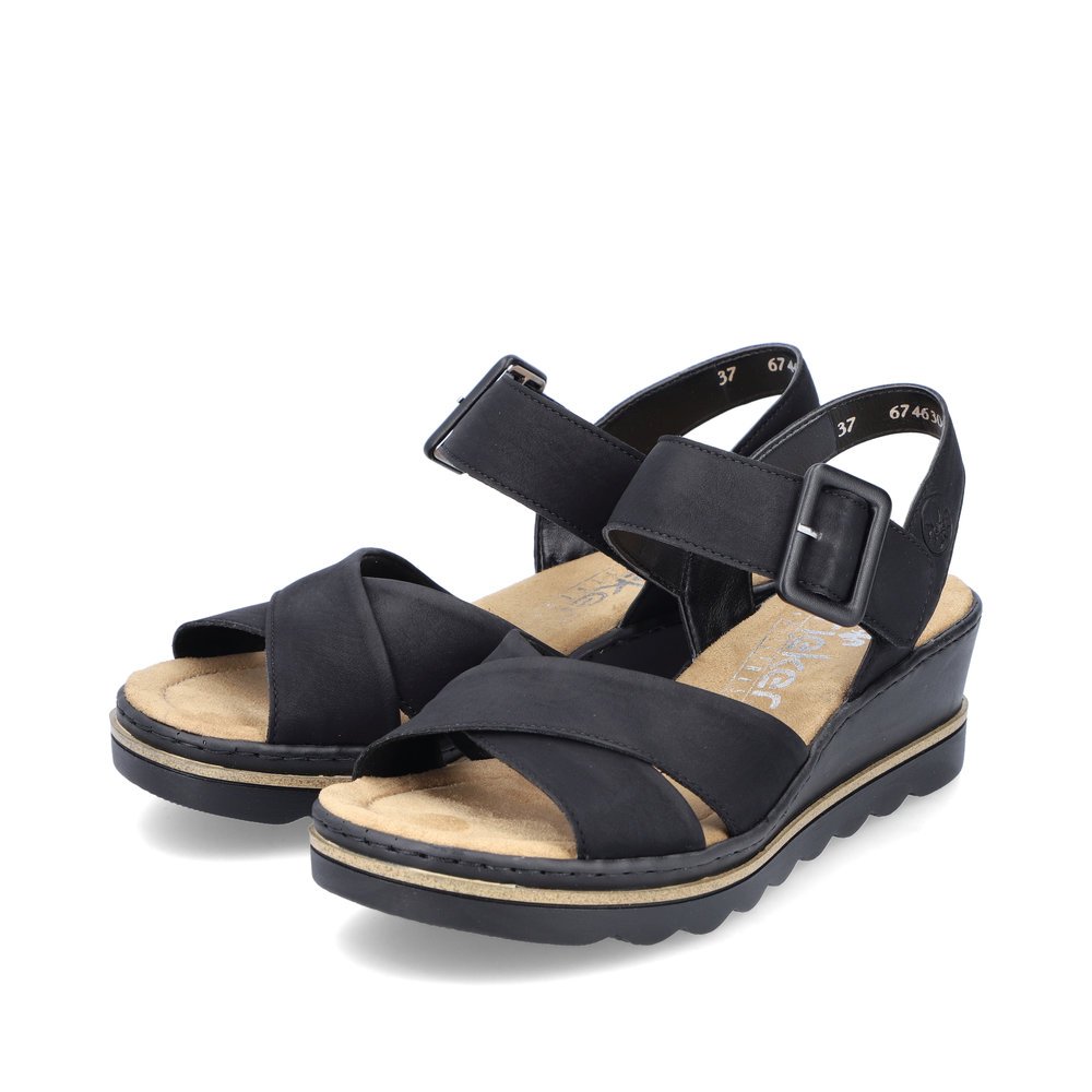Rieker sandales compensées noires femmes 67463-00 avec fermeture velcro. Chaussures inclinée sur le côté.