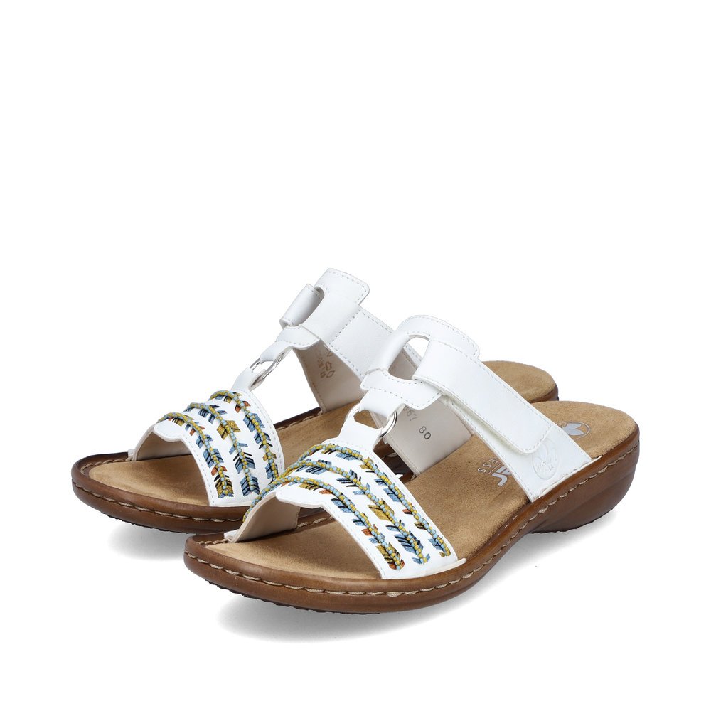 Brilliant white Rieker women´s mules 60867-80 with a hook and loop fastener. Shoes laterally.