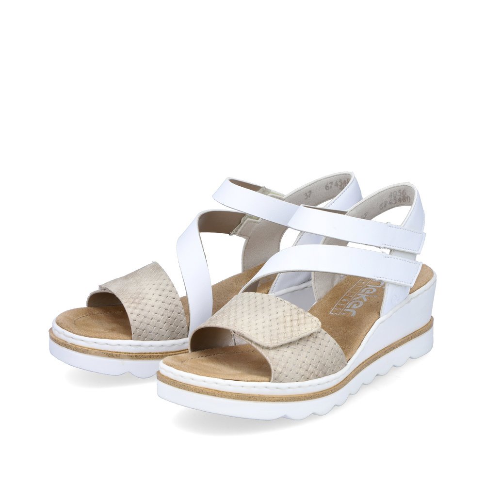 Rieker sandales compensées blanches femmes 67454-80 avec fermeture velcro. Chaussures inclinée sur le côté.